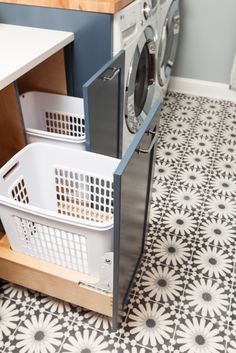 a washer and dryer sitting in a room next to each other on a tiled floor