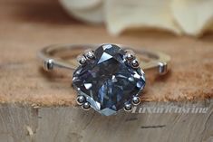 a diamond ring sitting on top of a piece of wood