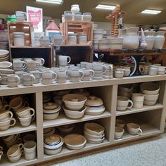 the shelves are full of dishes and cups for sale at the store or showroom