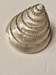 a clam shell on a white surface with beading around the bottom and sides