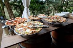 several pizzas are on the table ready to be served at an outdoor party or gathering