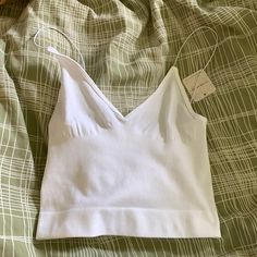 Free People White Cami Never Worn New With Tags White Stretch V-neck Camisole, Spring Tops With Built-in Bra For Relaxation, Low-cut Tops With Built-in Bra For Loungewear, White Seamless V-neck Top, Spring Relaxation Tops Bra Friendly, Spring Tops For Relaxation, Bra Friendly, White Seamless V-neck Crop Top, White Low-cut Summer Top, White Low-cut Top For Summer