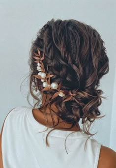 the back of a woman's head wearing a hair comb with pearls and leaves on it