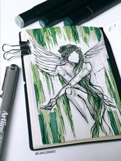 a drawing of an angel sitting on top of a book next to a marker and pen