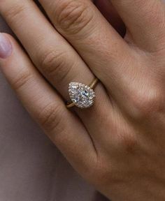 a woman's hand with a diamond ring on her finger and an engagement band