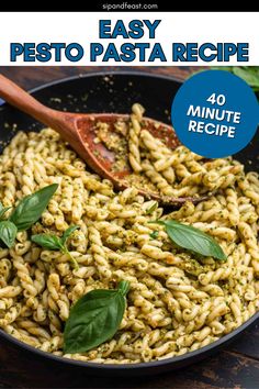 an easy pesto pasta recipe in a skillet with basil leaves on the side