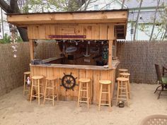 an outdoor bar made out of wood with stools