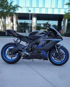 a black and blue motorcycle parked in front of a building