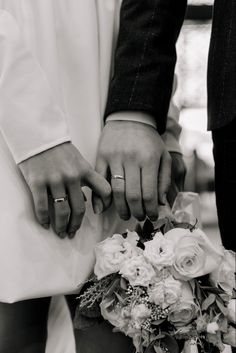 the bride and groom hold hands as they stand close to each other with their wedding rings on their fingers