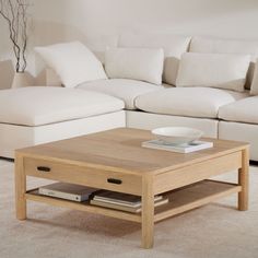 a living room with white couches and a coffee table in front of the couch