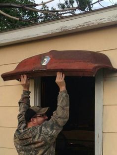 a man in camo holds up an old roof