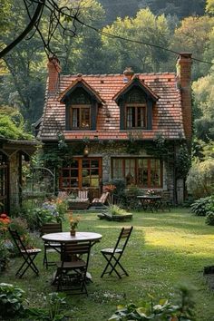 a house in the middle of a lush green yard with chairs and tables around it