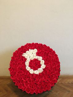 a large bouquet of red and white roses in the shape of a circle with a number on it