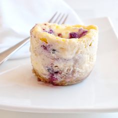 a muffin sitting on top of a white plate next to a fork