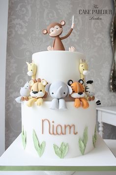 there is a cake decorated with animals on the top and one monkey sitting on top