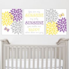 two wall art prints with purple and yellow flowers in the nursery's crib