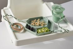 a tray with beads, bracelets and other items on it sitting on a table