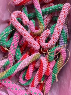 many colorful crocheted objects are in a pink bag with twine spools