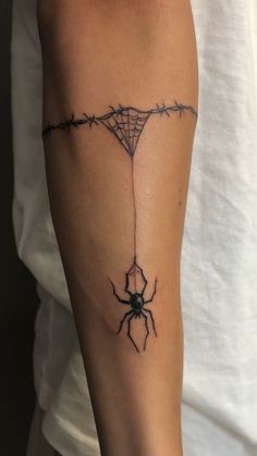 a spider web tattoo on the arm