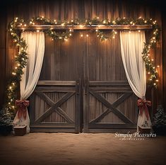 an open barn door decorated for christmas with lights and garlands on the doors,