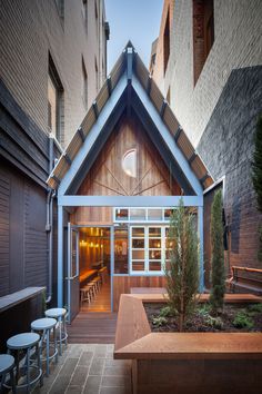 the outside of a building with tables and stools in it's courtyard area