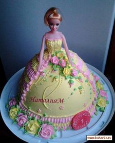 there is a cake that looks like a barbie doll on top of a plate with flowers