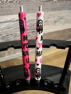 two pink and black pens sitting on top of a chair