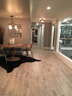 a living room filled with furniture and a wooden table on top of a hard wood floor