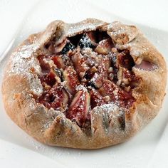 a close up of a pastry on a plate with powdered sugar and jelly toppings