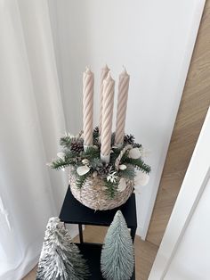 a christmas arrangement with candles and pine cones