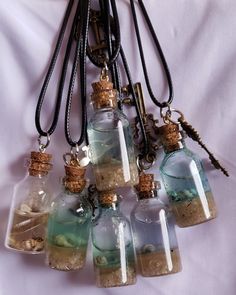 This ocean scenery bottle necklace features mini glass bottles with a blend of water, sand, seashells and resin, artfully arranged to create a breathtaking underwater seascape. The captivating design makes a unique statement piece, ideal for any beach or ocean-inspired outfit. Beach Sand Necklace, Mini Glass Bottle Necklace, Sand And Seashells In Jar, Sand Jars From Vacation, Ocean Outfit Ideas, Ocean Themed Accessories, Seashell Resin Art, Beach Sand Crafts, Ocean In A Bottle