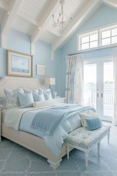 a bedroom with blue walls, white furniture and a chandelier hanging from the ceiling