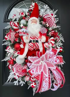 a christmas wreath with santa claus and candy canes on it, hanging from the front door