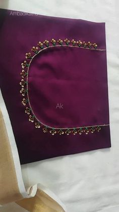 a purple cloth with gold beading on it