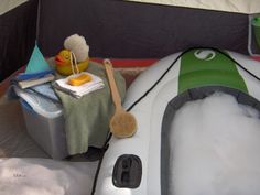 an inflatable boat with a brush on it and other items sitting next to it