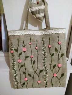 a handbag hanging on the wall with pink flowers