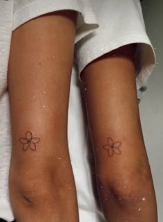 two people with matching tattoos on their legs, one has a flower tattoo on the other