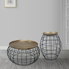 two metal vases sitting next to each other on top of a carpeted floor