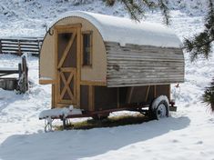 a small wooden trailer sitting in the snow