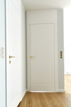 an empty room with white doors and wood floors