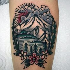 a tattoo on the leg of a person with mountains and trees in the background,