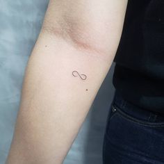 a woman's arm with a small tattoo on the left side of her arm