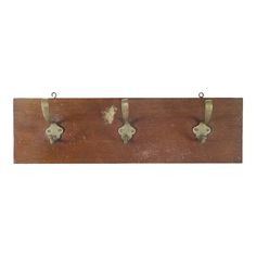 three metal hooks hang on a wooden board