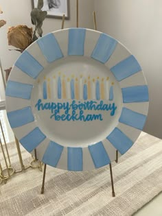 a birthday plate with candles on it sitting on a table next to other plates and vases