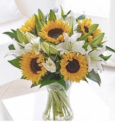 a vase filled with white and yellow flowers