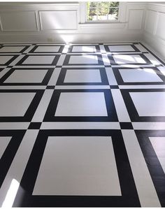 a black and white tiled floor in an empty room with sunlight coming through the window