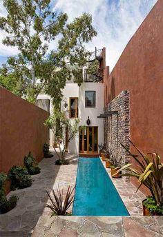 an outdoor swimming pool surrounded by plants and trees