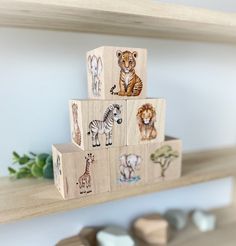 wooden blocks with animals on them sitting on a shelf in a children's room