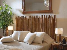 a bed with white pillows and wooden headboard