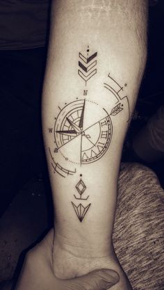 a black and white photo of a tattoo on someone's leg with an arrow